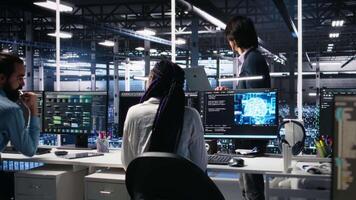 equipo líder supervisando técnicos en servidor habitación utilizando ai a revisión infraestructura diagnósticos asiático hombre en datos centrar analizando actuación de trabajadores utilizando artificial inteligencia, cámara un video