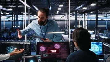 systemet administratörer i data Centrum kamp med dator buggar medan använder sig av ai. frustrerad server bruka medarbetare håller på med brainstorming till fixera systemet fel medan använder sig av artificiell intelligens, kamera en video