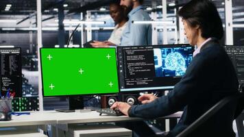 Data center admin typing on isolated screen PC keyboard, using AI. IT specialist at work using artificial intelligence on chroma key computer to oversee servers powering deep learning, camera A video