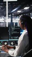 vertical dados Centro computador cientista usando ai assistente para providenciar do utilizador técnico apoiar. africano americano mulher dentro servidor Fazenda gerenciando viver Apoio, suporte chamadas assistido de artificial inteligência, Câmera uma video