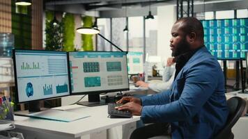 africano americano consultor comprometido en planificación y análisis con computadora resultados a crear estrategia informes para accionistas. trabajando en innovación, objetivos alineación y crecimiento. cámara una. video