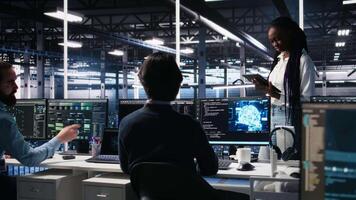 tekniker i hög tech data Centrum samarbeta på neuralt nätverk programvara utveckling. server nav den arbetare talande, genomförande djup inlärning teknologi använder sig av pc, kamera en video