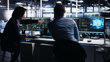 data Centrum systemet administratörer använda sig av pc till övervaka neuralt nätverk använder sig av ai llm. asiatisk man och kollega på arbete använder sig av artificiell intelligens till övervaka servrar driver maskin inlärning, kamera en video