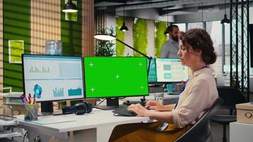 ejecutivo asistente analizando kpi métrica en computadora monitor con Bosquejo, manejo tarea terminación con infografia y datos analítica en ordenador personal. mujer de negocios viendo perspectivas. cámara una. video