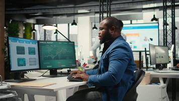 negro empresario de corrección su malo postura a el puesto de trabajo, relación comercial con espalda y cuello músculo dolor debido a intenso trabajar. administrador resolviendo Tareas para productividad y eficiencia. cámara una. video