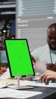 Vertical Business colleagues meeting late in the office with green screen tablet, team members exchange forecasting files and establish project targets. Performance indicators for success. Camera A. video
