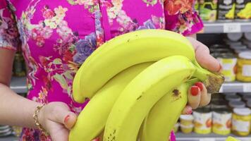 Bananas in a womans hands against a store display window, creating a fresh and appealing image video