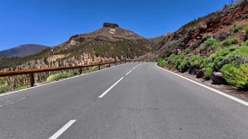 A winding road meanders through stunning mountains beneath clear skies, embodying tranquility and adventure video