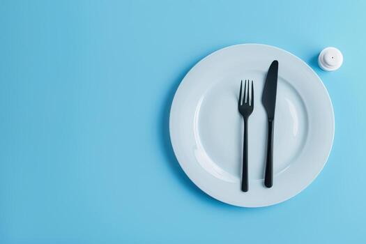 Elegant Plates and Cutlery Arranged on a Blue Table, Perfect for a Stylish Dining Setting photo