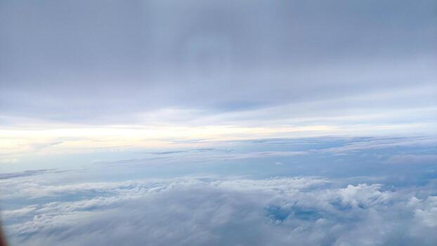 A serene sky view featuring soft clouds taken from a plane in flight photo