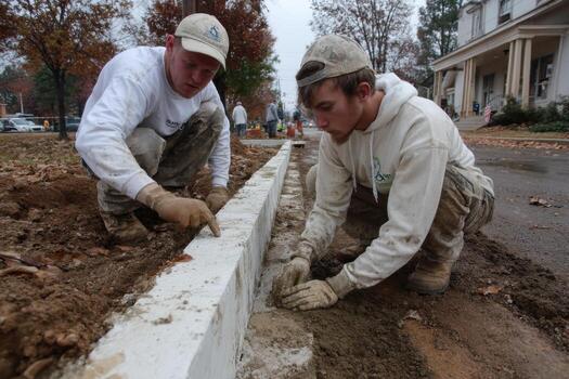 Two men working on a cement block wall photo