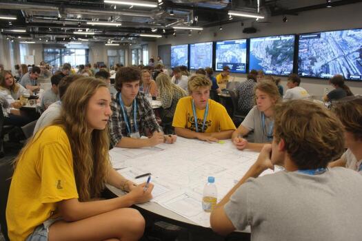 A group of people sitting around a table with a map photo