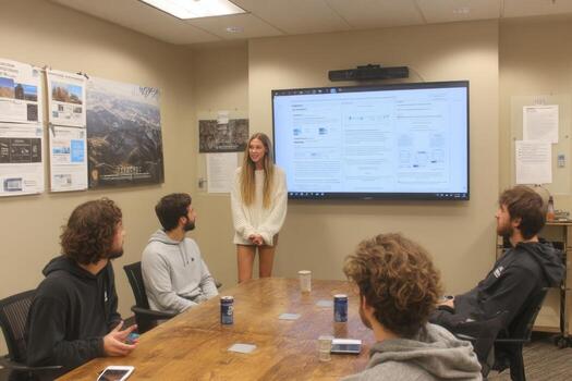 A group of people sitting around a table in a conference room photo