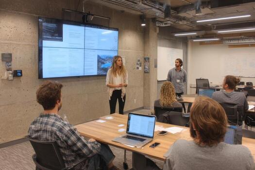 A group of people in a room with a large screen photo