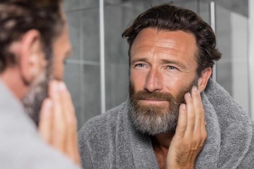 A man with a beard looking in the mirror photo