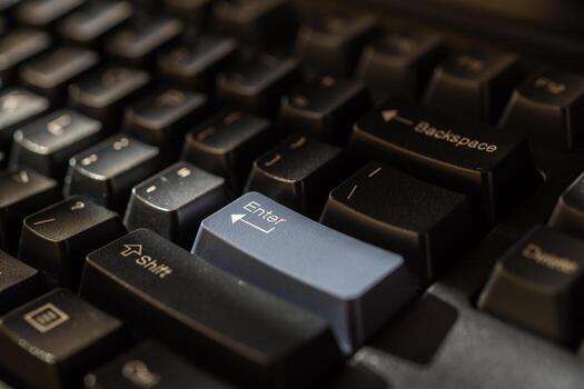 A close up of a computer keyboard with a blue button photo