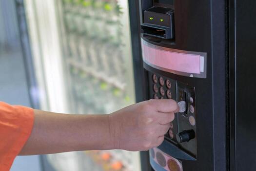 A person is using a key to open a vending machine photo