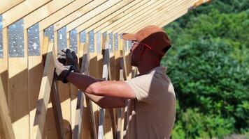 trabalhador constrói de madeira estrutura dentro ao ar livre construção projeto durante ensolarado dia video