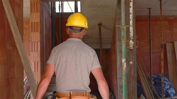 trabalhador prepara para construção tarefas dentro uma parcialmente construído estrutura video