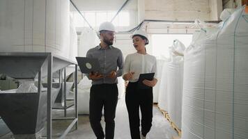 ingenjörer gående och diskuterar i fabrik använder sig av bärbar dator och läsplatta video