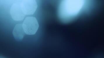 verklig blå ljus läckage och slingor med hexagonal bokeh på svart bakgrund med kaotisk rörelse för täcka över. video