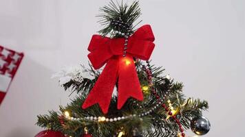Christmas tree with beads, balls, shape of snowflake, bows and garland, camera movement from top to bottom, on the background of the Christmas tree on white background. Christmas Time. video