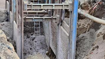 detta är en omfattande se av ett utgrävd område den där funktioner stöttning och en stege på ett aktiva konstruktion webbplats video
