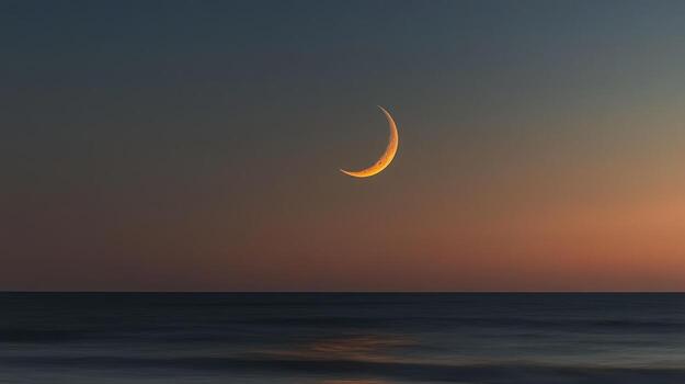 Crescent moon over a tranquil ocean at sunset photo