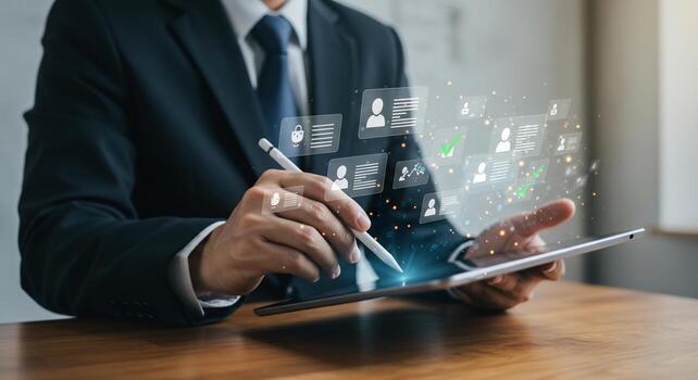 Businessman using stylus on tablet, interacting with floating digital user profiles and data icons, symbolizing modern HR and data management. photo