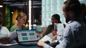 multietnisk kollegor granskning Framgång och effektivitet metrik inom de fast, presenter projekt insikt. team medlemmar utvärdera data rapporter och prognoser, produktivitet och framsteg. kamera a. video