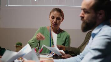 olika projekt team aktier analys rapporter under rådgivande styrelse händelse efter timmar, granskning företag intel och framställning insikt för kommande presentation med rådgivare. kamera b. video