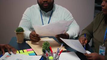 dichtbij omhoog van verschillend personeel samenwerken Aan gegevens voorspelling en analyse, uitwisselen documenten laat in de kantoor. updaten belanghebbenden met voorspellingen en andere bedrijf inlichtingen camera a. video