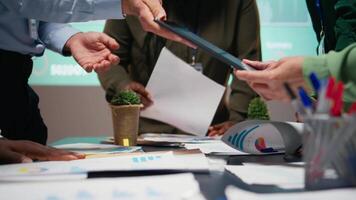 After hours briefing with multiethnic group gathering in a strategy room, analyzing visual data, statistics and risk assessment files for project development, productivity. Camera A. video