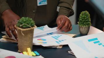 multi-etnisch voorspelling team herzien verslag doen van bestanden gedurende belangrijk ontmoeting, updaten project agenda en bespreken bedrijf ontwikkeling met aandeelhouders in kantoor na uur. camera b. video