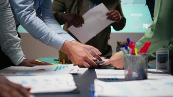 verschillend bedrijf team uitwisselen inzichten en voorspelling diagrammen in een laat nacht ontmoeting, herzien financieel gegevens analytics en bedrijf inlichtingen adviserend bord samenwerking. camera a. video