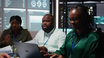 svart verkställande assistent övervakning huvudstad medel och inkomst data på rapporter i möte, granskning vinst öka och budget tilldelning för en projekt. informativ natt session. kamera a. video