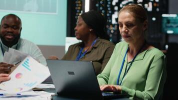 kvinna handledare och henne personal medlemmar granskning effektivitet metrik inom företag, presenter projekt insikt under en möte. data rapporter och prognoser för produktivitet. kamera b. video