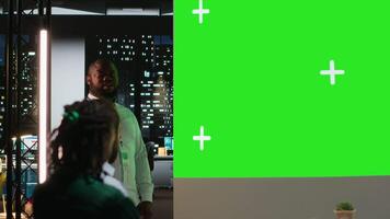 multietnisk projekt team Arbetar sent i en mörk kontor med kopia Plats, samarbetande på budgetering, rapportering och miljö företag mål under natt möte på en multinationell företag. kamera b. video