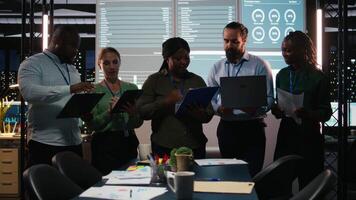 Portrait of multiethnic business team collaborating late at night, assembling in a dark office after hours and working on enterprise development. Diversity within the advisory board group. Camera A. video