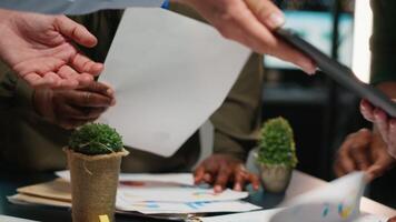 After hours briefing with multiethnic group gathering in a strategy room, analyzing visual data, statistics and risk assessment files for project development, productivity. Camera B. video