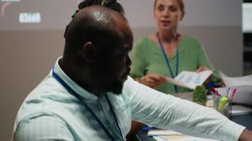 Close up of diverse business team meeting after hours for visual data reports, reviewing infographics and projections while sharing files to establish finance objectives. Business intel. Camera B. video