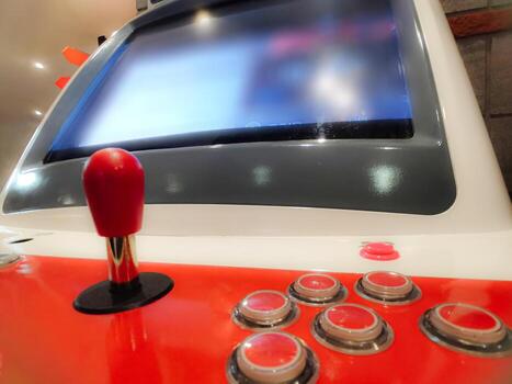 Vintage arcade machine with red joystick and buttons creating a nostalgic gaming atmosphere photo