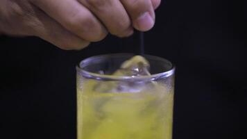 Hand Rühren vereist Orange Saft im Glas mit Stroh. Mischen Orange Saft mit Eis und Stroh video