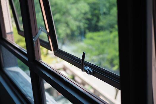 Window open to a view of lush greenery in a sunny setting photo