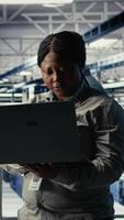 verticale dati centro tecnico schiera macchina apprendimento Software su infrastruttura cremagliere. africano americano donna nel server azienda agricola treni ai sistemi con set di dati utilizzando il computer portatile per supporto applicazioni, telecamera un' video