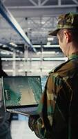 Vertical Military data center expert using ballistic missiles radar on laptop to watch for enemy threats. Army soldier in data center uses scanner tech to detect rockets launched by enemy troops, camera A video