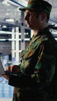 vertikal armén soldat i server bruka användningar artificiell intelligens program på bärbar dator till recension spaning information. militär data Centrum arbetstagare användningar djup inlärning till planen uppdrag, kamera b video