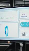 Vertical Empty office desk with a TV monitor running performance reports and other infographics, forecasting documents to ensure business growth, success and strategic objectives alignment. video