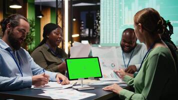 collega's team werk laat Bij nacht herzien rapporten met kopiëren ruimte, analyseren trends en samenwerken Aan strategie updates ondersteund door zichtbaar gegevens. bedrijf projecties met analyses. camera a. video