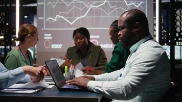 ritratto di nero supervisore presentazione capitale fondi previsioni e dati su attività commerciale grafici durante in ritardo incontro, risorse assegnazione per un' sviluppo progetto. riunione conferenza. telecamera un. video